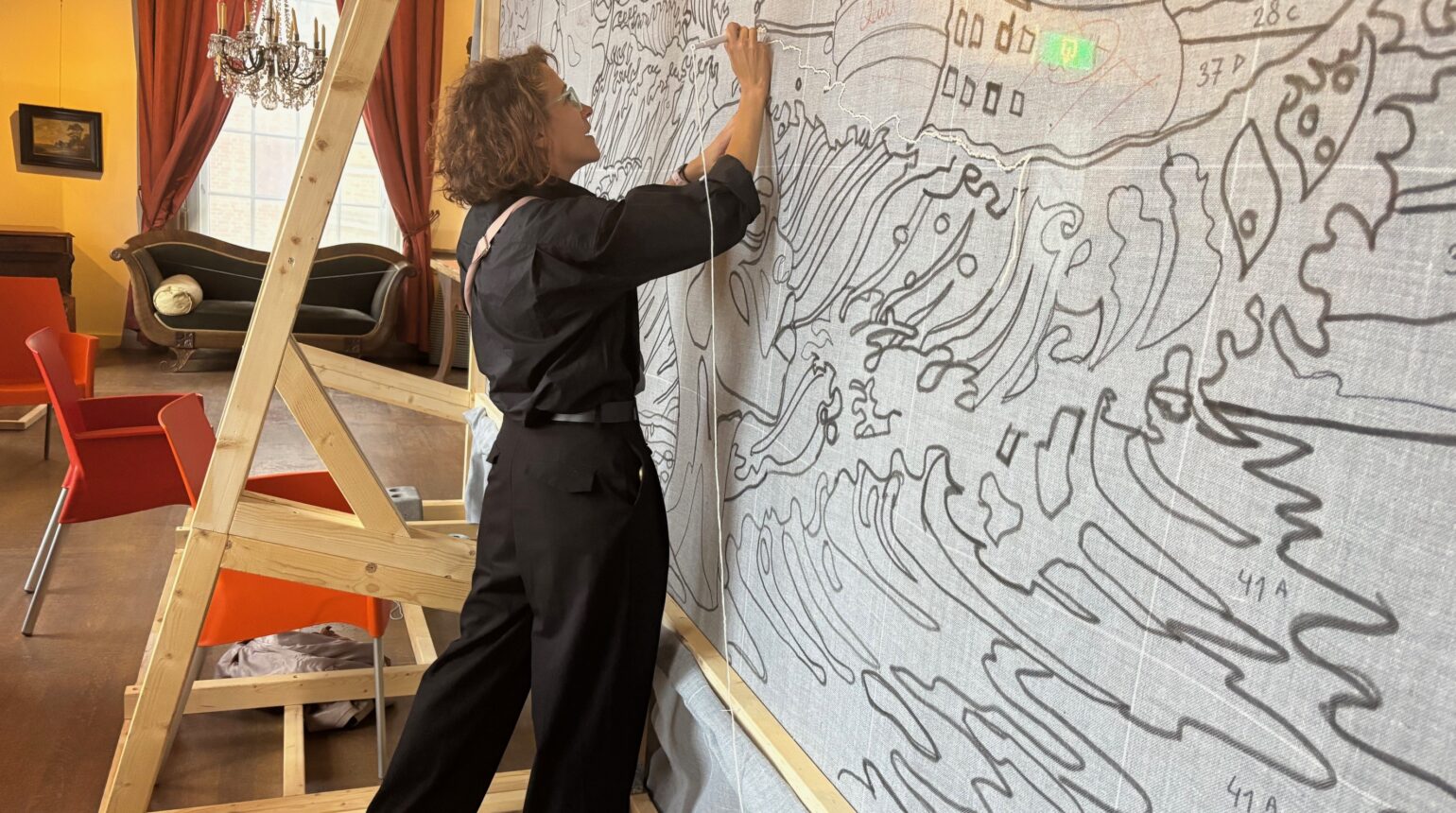 Vrouw bewerkt een wandtapijt