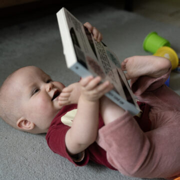 Een baby houdt een boek vast